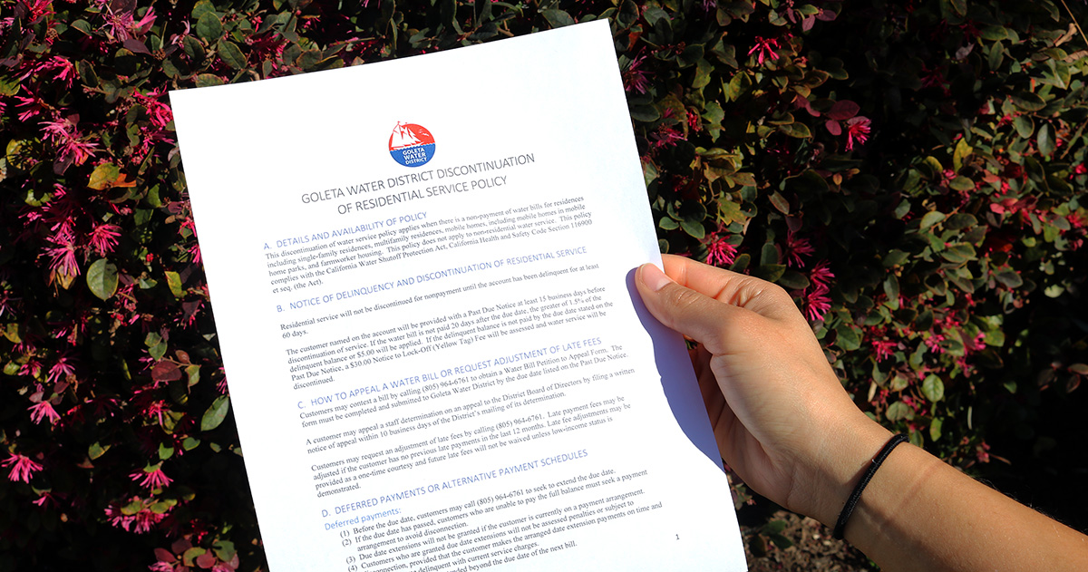 A person's hand holding a letter from the Goleta Water District