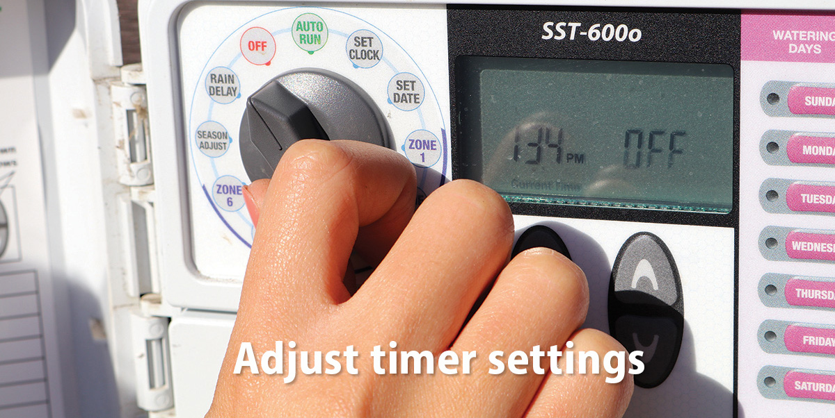 Adjust timer settings (hand adjusting an irrigation controller switch)