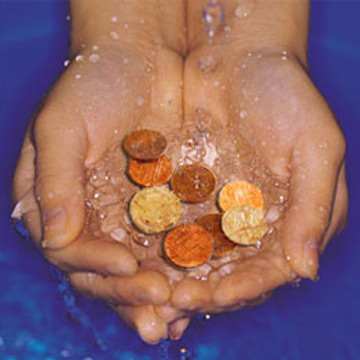 Hands holding coins with water splashing over them