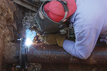 Technician welding a pipe
